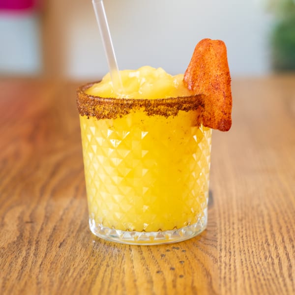 A Polanquito mango margarita with a chili-lime rim and a chili-dusted mango slice.